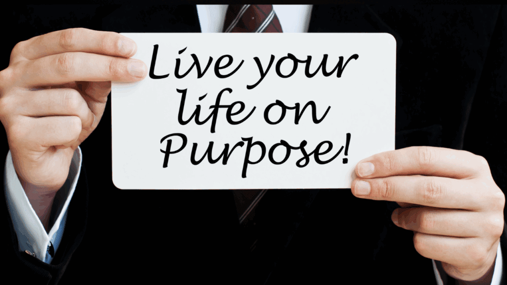Man holding a sign that says Live Your Life On Purpose - Find Your Passion, Discover Your Purpose, Adopt a Positive Mindset with Brain-Based Neural Development Man holding a 'Live Your Life On Purpose' sign after discovering his life's passion and purpose and adopting a positive mindset through brain-based neural development.