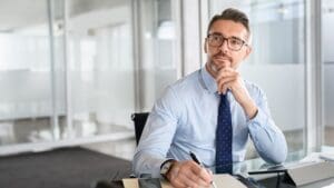 Imposter Syndrome's Silent Contemplation in the Workplace Man at work deep in thought, reflecting on imposter syndrome feelings.