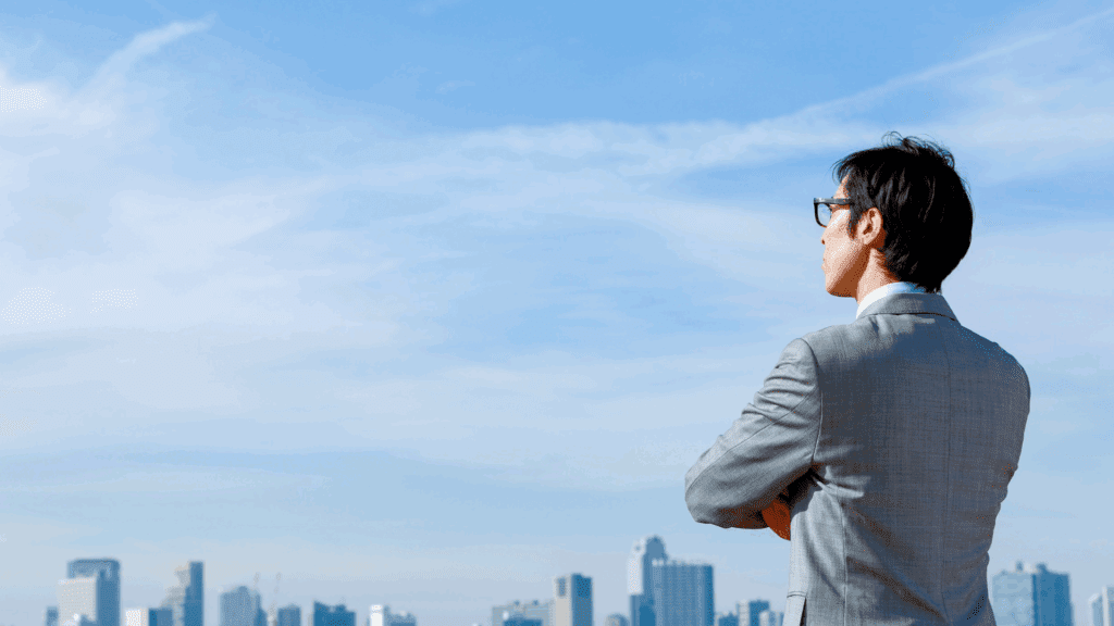 Business professional reflecting on the city skyline, symbolizing negative thoughts on career growth.