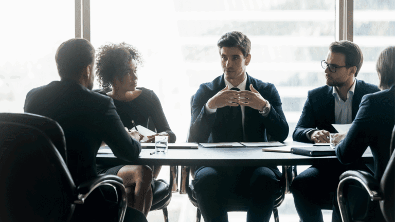 Leadership development shown by a group of executive professionals at a conference table who have learned neuroscience-based executive development