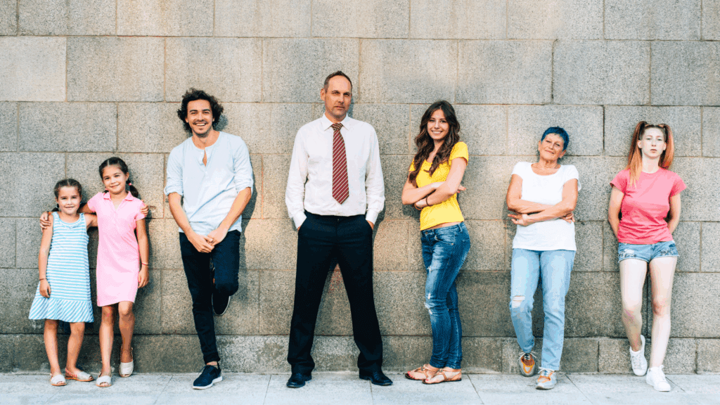 Diverse group of people standing against a concrete wall