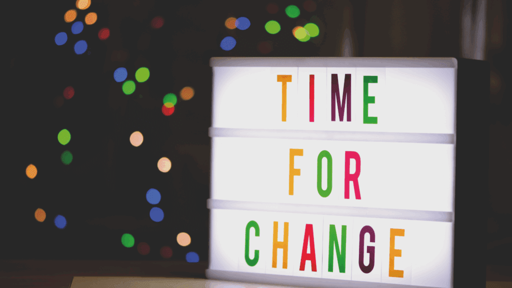A lightbox with the phrase "Time for Change" illuminated against a festive, colorful background.
