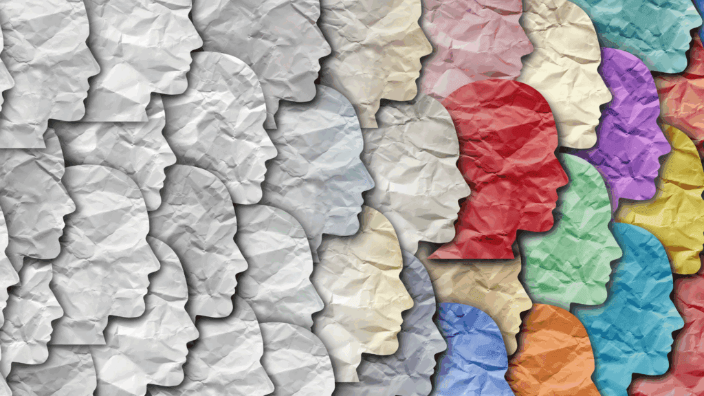 Profiles of diverse faces made of crumpled paper in various colors, symbolizing individuality and personal growth. 