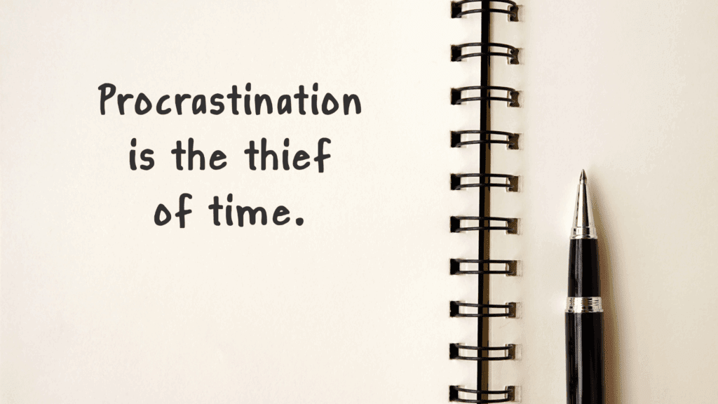 Open notebook with the phrase "Procrastination is the thief of time" written on a page.