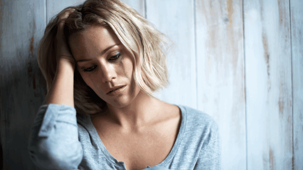 A distressed woman with tears on her face, depicting the emotional toll of compulsive hoarding.
.
