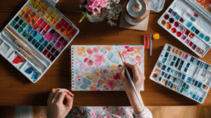 Person painting colorful watercolor flowers as a form of creative expression for anxiety and emotional release.