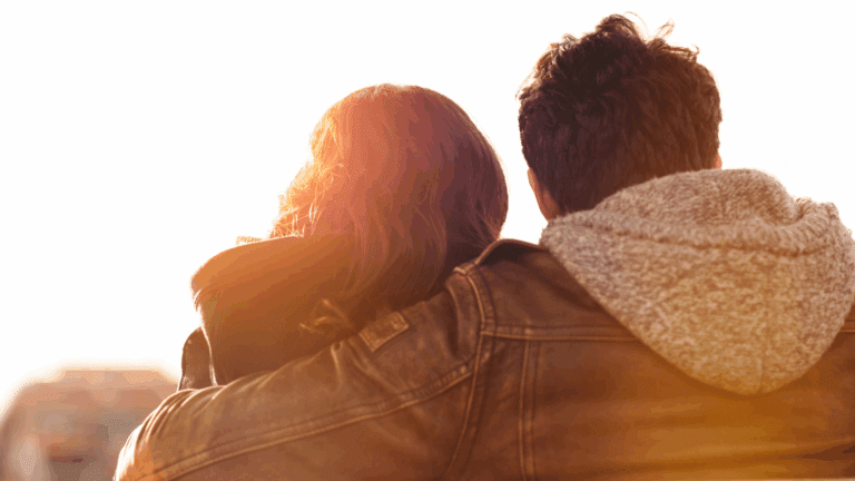 Couple embracing at sunset, symbolizing the emotional difference between wanting versus needing in relationships.
