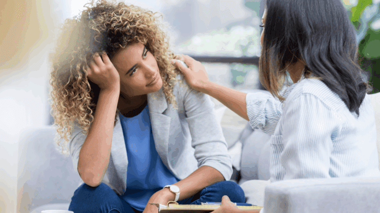 Mental health professional comforting a young woman during a counseling session, illustrating early intervention mental health 2025 support.