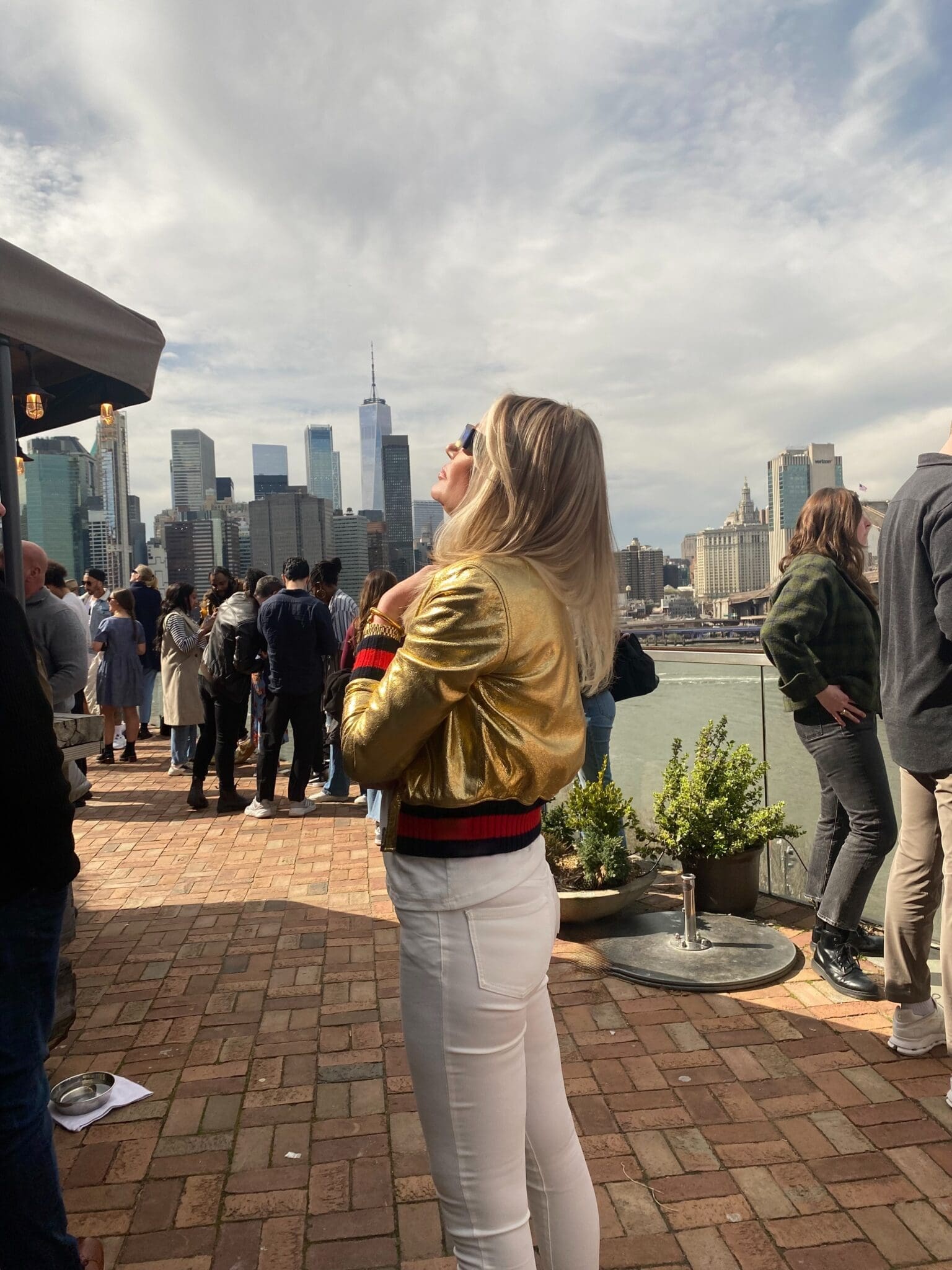 Dr. Sydney Ceruto in gold jacket looking at Freedom Tower NYC showing confidence and high-achiever mindset