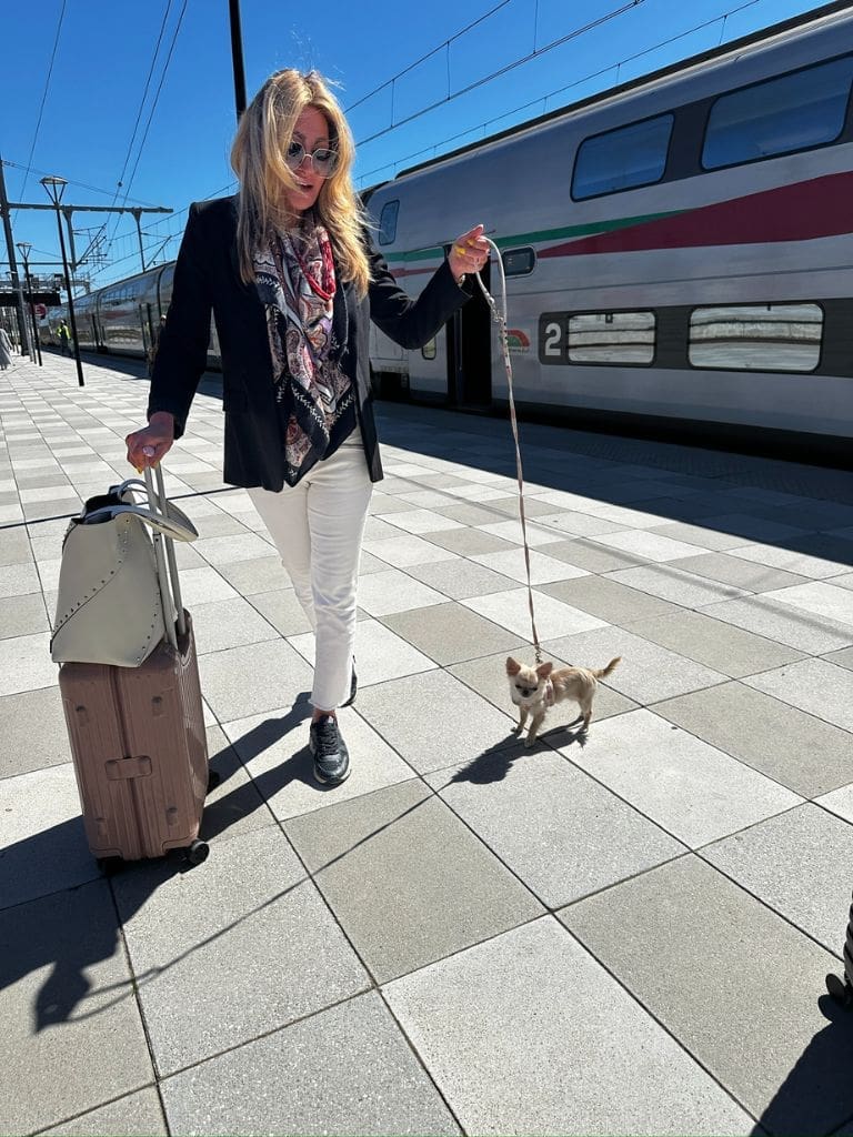 Dr. Sydney Ceruto, MindLAB Neuroscience neuro-advisor, walking along a Moroccan train platform with her dog and luggage in Casablanca