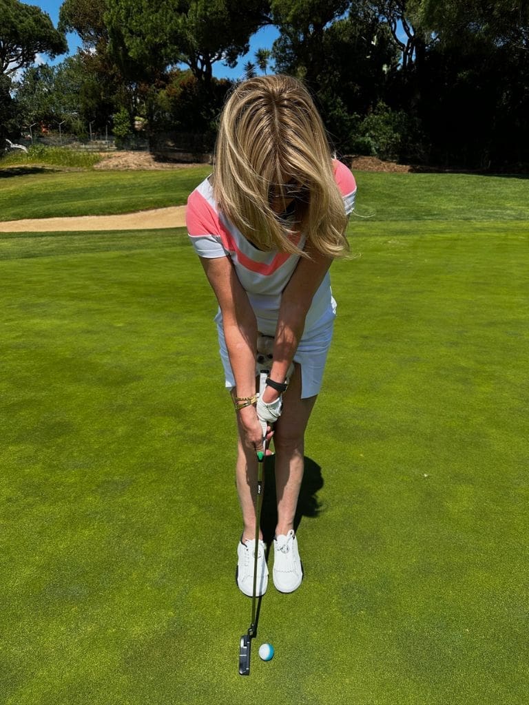 Dr. Sydney Ceruto lining up a birdie putt on a lush green golf course in Lisbon, Portugal