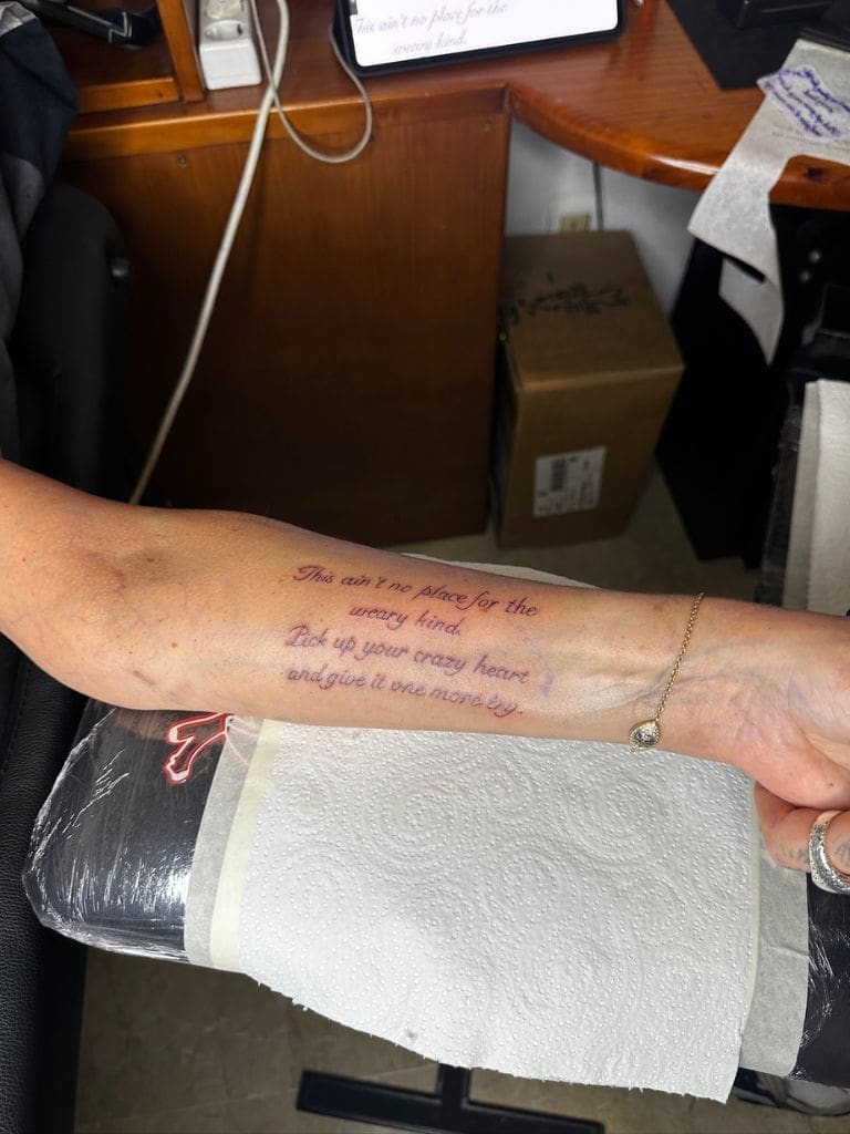 Close-up of Dr. Sydney Ceruto's forearm tattoo with an inspirational message about resilience and perseverance freshly inked at a tattoo studio